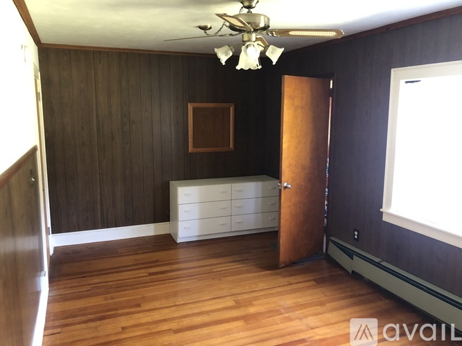 A room with wooden floors and a ceiling fan.