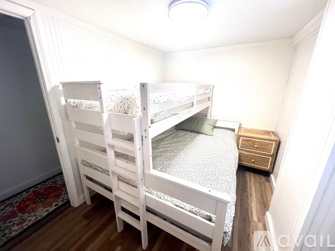 A bedroom with two bunk beds and a dresser.
