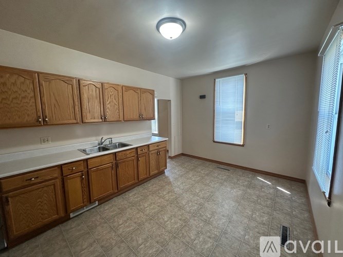 A kitchen with wooden cabinets and a tiled floor.