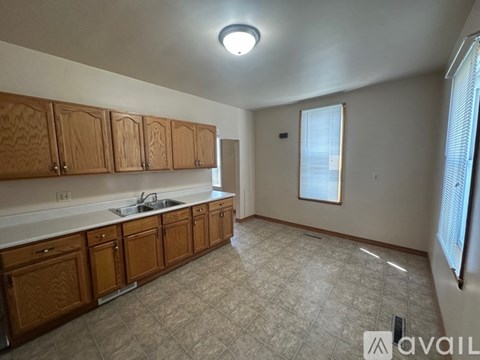 A kitchen with wooden cabinets and a tiled floor.