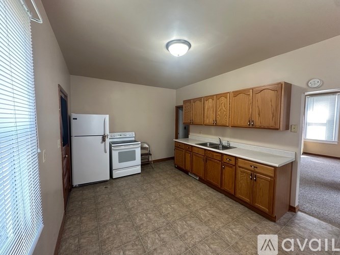 A kitchen with white appliances and wooden cabinets.