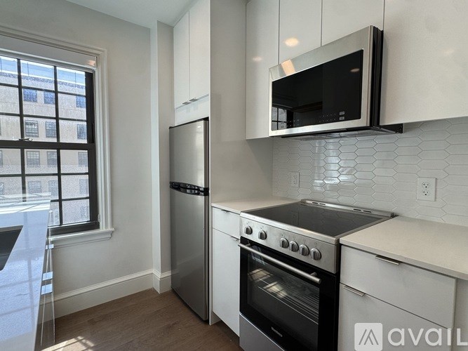 A kitchen with a stainless steel refrigerator, oven, and microwave.