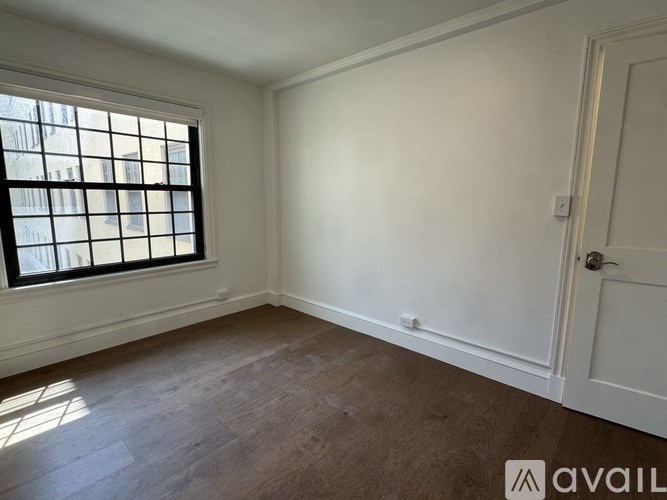 A room with a window and wooden flooring.