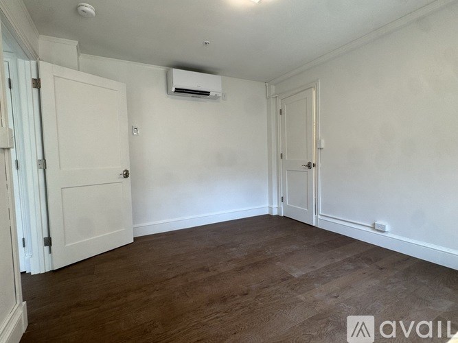 A room with wooden floors and two doors.