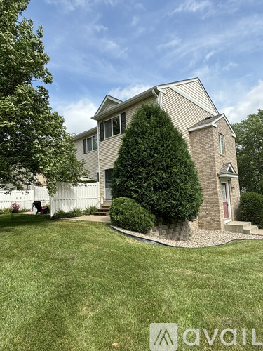 A house with a white fence and a green lawn.