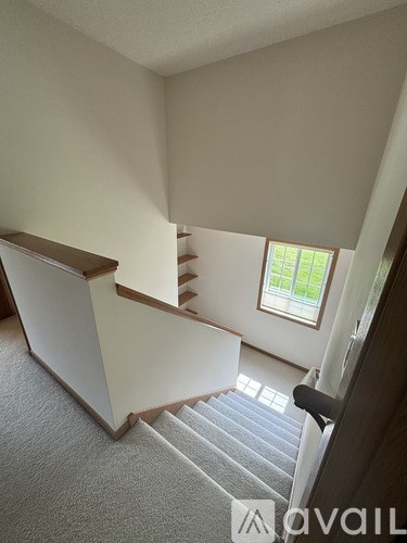 A staircase with a carpeted floor and wooden handrails.