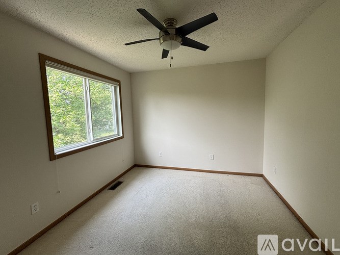 A room with a ceiling fan and a window.