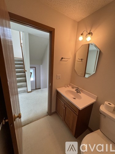 A bathroom with a sink, mirror, and toilet.