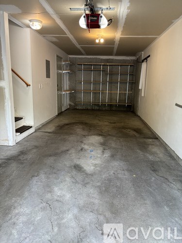 A large empty room with a concrete floor and white walls.
