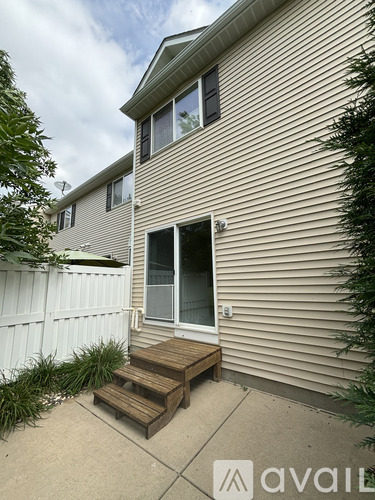 A house with a white fence and a small deck.