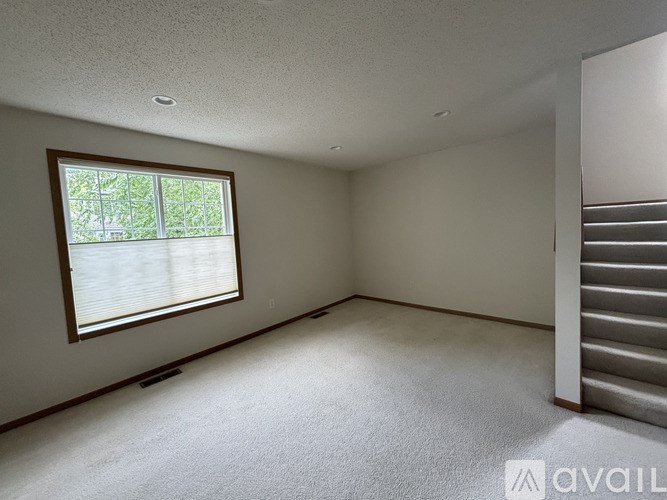 A room with a window and a staircase.