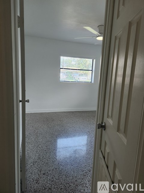 A room with a door and a window with blinds.