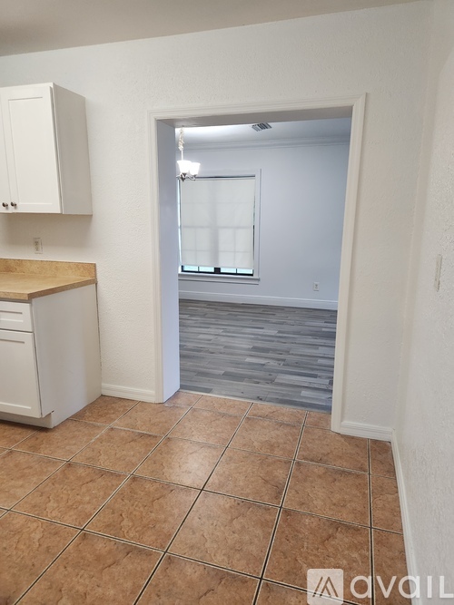 A kitchen with white cabinets and a tiled floor.