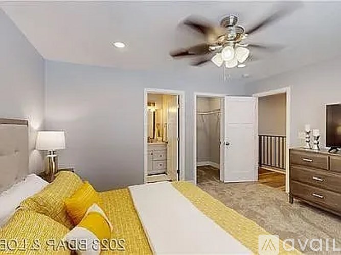 A bedroom with a bed, dresser, and ceiling fan.