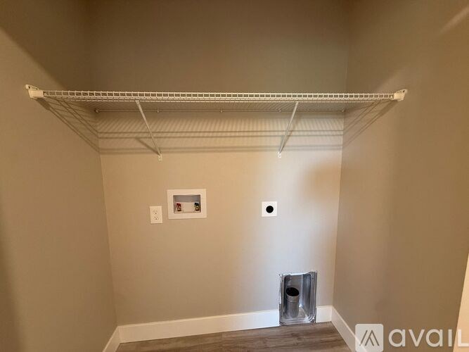 A living room with a grey couch, a white coffee table, and a painting on the wall.