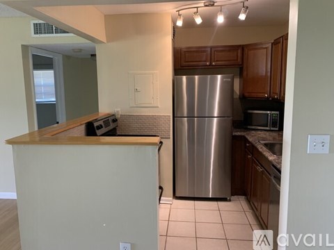 A kitchen with a refrigerator, microwave, and oven.