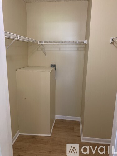 A small, empty closet with a white shelf and a white door.