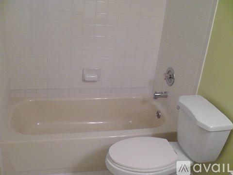 A white toilet sits next to a bathtub in a bathroom.