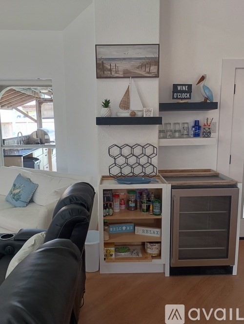 A living room with a black leather couch and a white sofa.