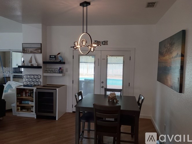 A dining room with a table and chairs and a chandelier hanging from the ceiling.