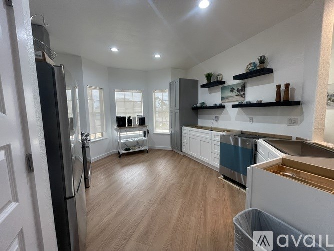 A kitchen with a refrigerator, oven, and sink.