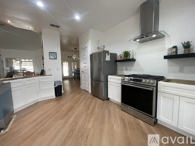 A kitchen with white cabinets and a black stove top oven.