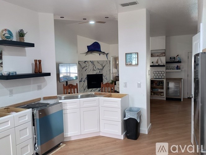 A kitchen with white cabinets and a blue backsplash.