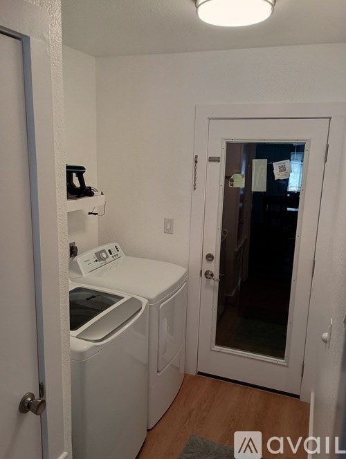 A small laundry room with a washer and dryer.