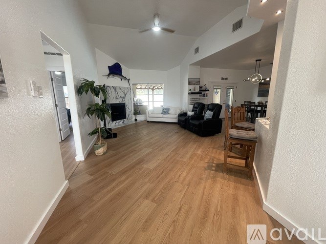 A living room with a fireplace and a ceiling fan.