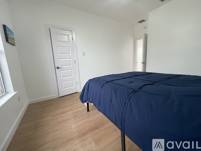 A bedroom with a bed covered in a blue sheet.
