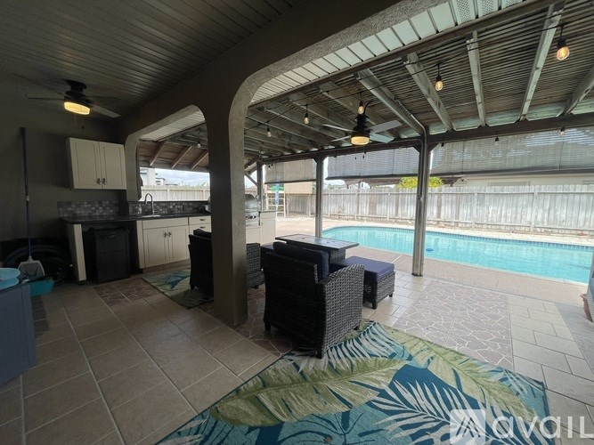 A patio with a pool and a kitchen area.
