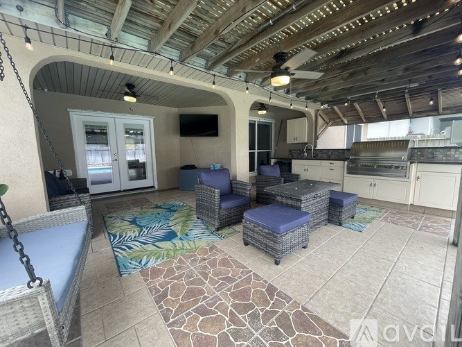 A patio with a blue cushion and a fan.