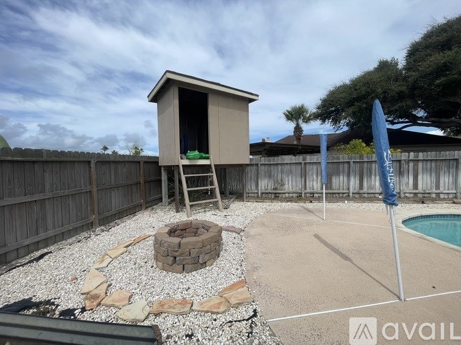 A backyard with a pool and a small building.