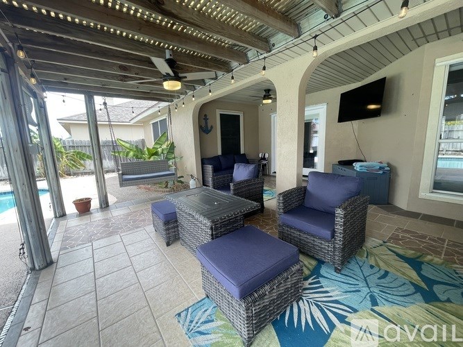 A patio with a couch, chairs and a rug.