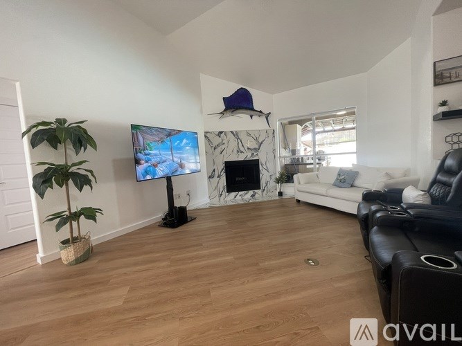 A living room with a flat screen TV and a fireplace.