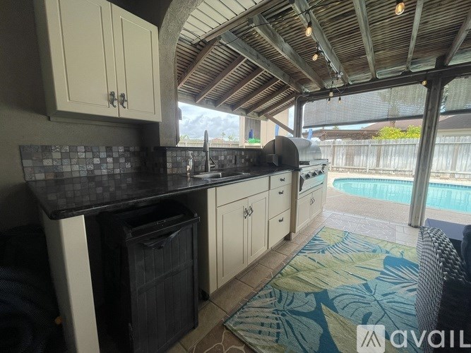 A kitchen with a black countertop and white cabinets.