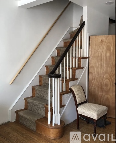 A wooden staircase with a chair beside it.