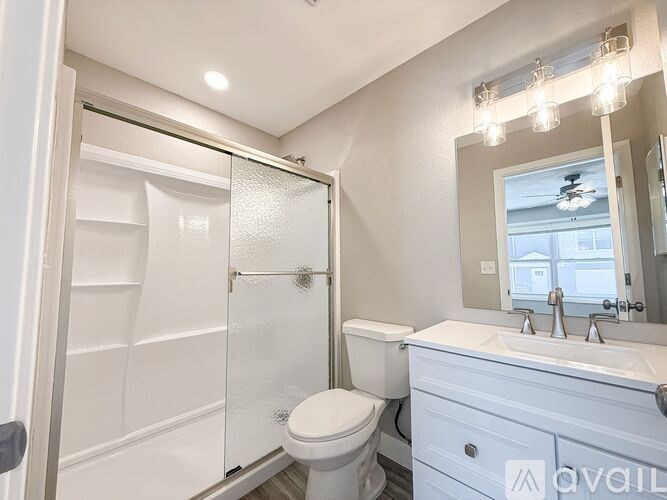 A bedroom with a large bed and a ceiling fan.