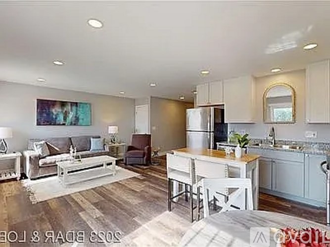 A modern kitchen and living room with a dining table and chairs.