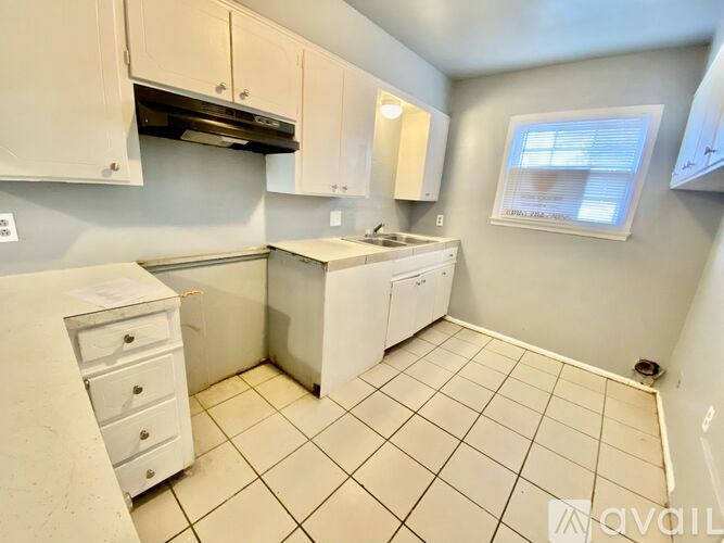 A small kitchen with white appliances and cabinets.