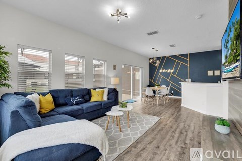 A living room with a blue couch and a white blanket on it.