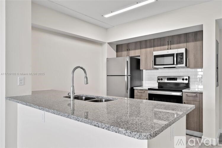 A kitchen with granite countertops and stainless steel appliances.