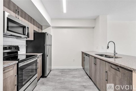 A kitchen with a black refrigerator, stove, and oven.