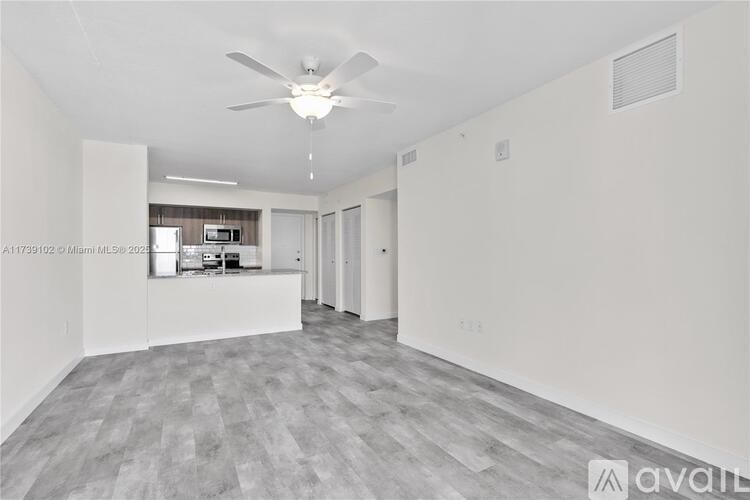 A spacious room with a ceiling fan and a grey floor.