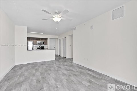 A spacious room with a ceiling fan and a grey floor.