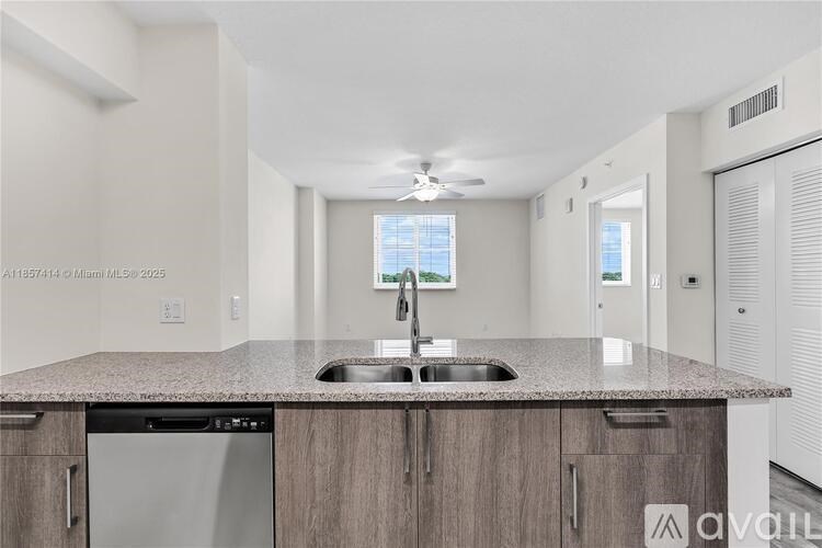 A kitchen with a granite countertop and stainless steel appliances.