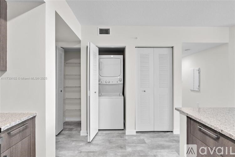 A kitchen with a white fridge and cabinets.