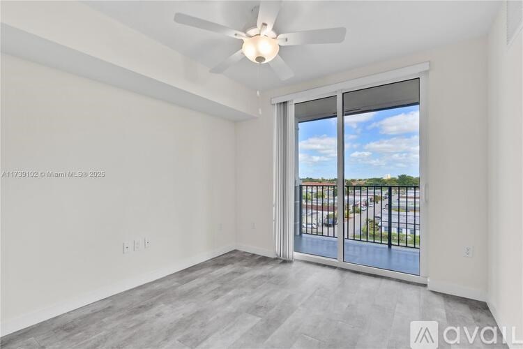 A room with a sliding glass door leading to a balcony.