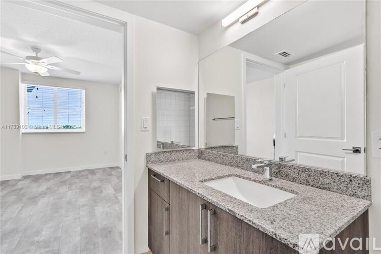 A modern bathroom with a large mirror, sink, and cabinets.