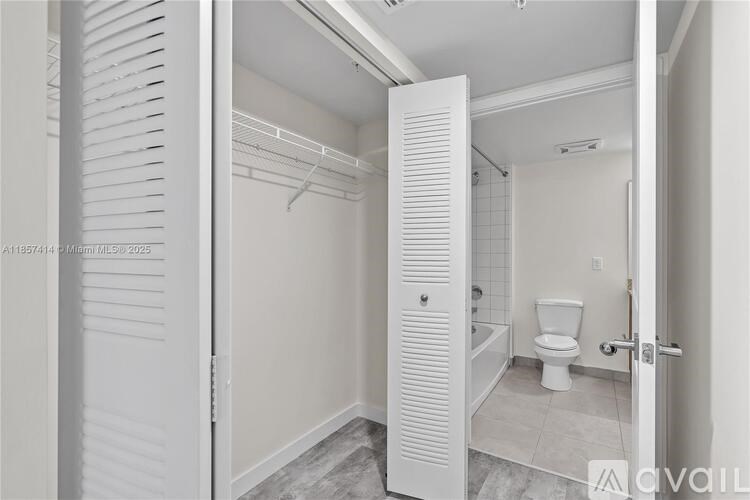 A white bathroom with a toilet, sink, and walk-in shower.